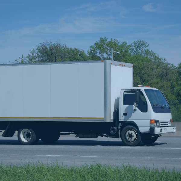 A white truck driving on the road.